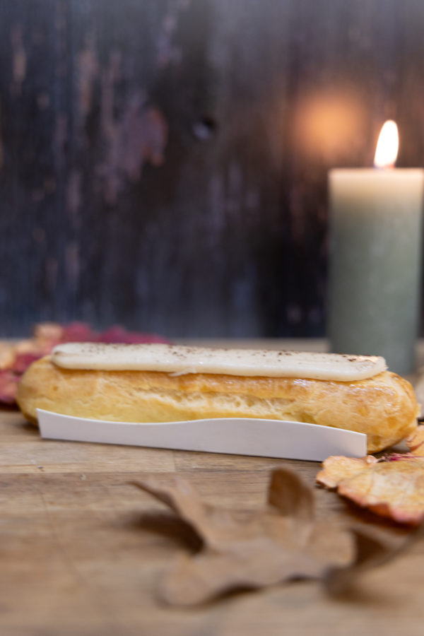 Un éclair généreusement garni de crémeux à la vanille de Madagascar et recouvert d'un glaçage saupoudré de poudre de vanille de Madagascar